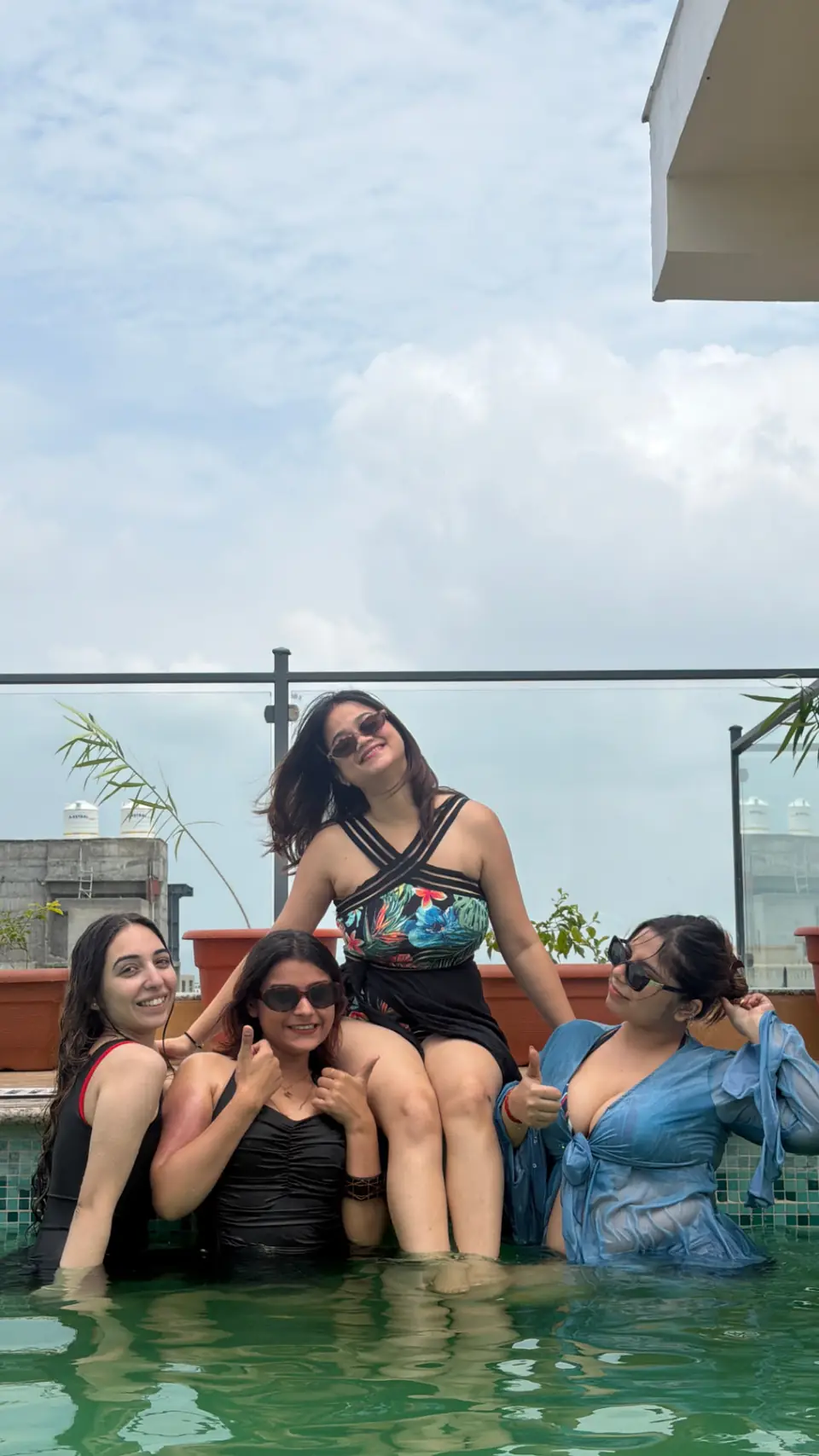 Travellers laughing together in a rooftop pool