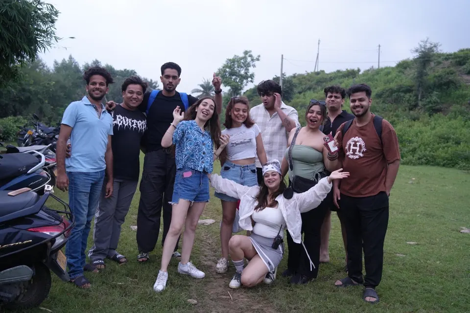 The group posing together on a grassy hillside after a monsoon walk